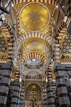 Ornate interior of Notre-Dame de la Garde Basilica with arches and golden mosaics