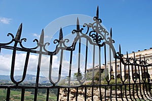 Ornate iron fence panel on the New Bridge with views across the Spanish countryside, Ronda, Spain.