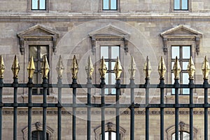 An ornate metal fence with gold-tipped spearhead finials photo