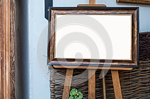 Ornate picture wooden frame on the easel in Art Gallery, Blank W