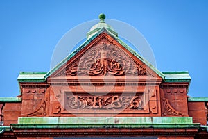 Ornate relief on top of a historic building.
