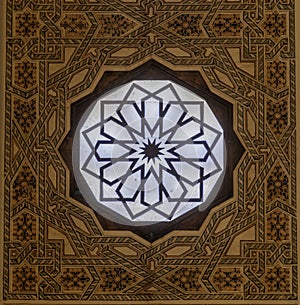 Ornate round window with patterned square frame taken in mosque