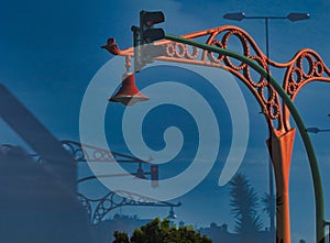 Ornate street lamp and a traffic light at dusk in A Coruna, Spain