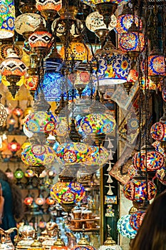 Ornate and vibrant collection of Turkish lamps hangs from the window of an authentic market