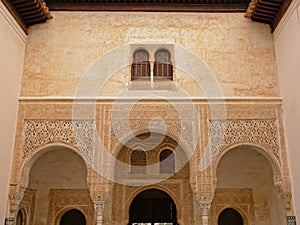 Ornate wall with arches and windows of Nasrid Palace , Alhambra, Spain