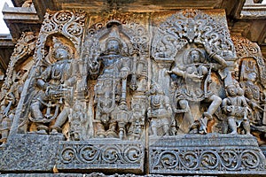 Ornate wall panel reliefs depicting from left Deity playing damaru, Vishnu and dancing Sarswati, Hoysaleshwara temple, Halebidu, K