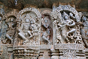 Ornate wall panel reliefs depicting from left Shiva-Parvati and dancing Sarswati, Kedareshwara temple, Halebidu, Karnataka