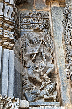 Ornate wall panel reliefs depicting Shiva dancing on demon, Andhakasura, Chennakesava temple, Belur, Karnataka.