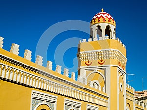 Ornate yellow wall and minaret in Melilla