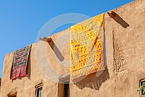 Ornated arabic carpets hanging from the roof of traditional mud houses, Al Ula, Medina province