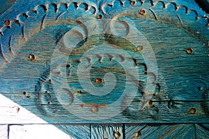 Ornately carved old wood with relief and blue paint. Wood grain and relief of a chic door frame or historic wooden cabinet. Blue photo