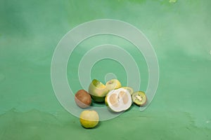 Oroblanco and other green fruits on a green background photo