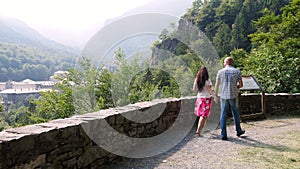 OROPA, BIELLA, ITALY - JULY 7, 2018: beautiful couple man and woman walking in park in mountains, near Shrine of Oropa