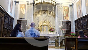 OROPA, BIELLA, ITALY - JULY 7, 2018: people sit on the benches, at the altar, in the catholic church. Shrine of Oropa