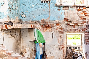 Orphaned children, poor child standing in a destroyed and abandoned building, staged photo