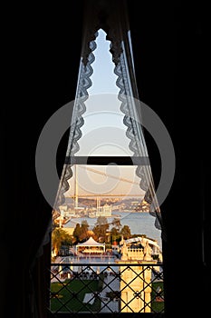 Ortakoy Buyuk Mecidiye Mosque and 15 Temmuz Sehitler Bogazici Bridge through a window with lace curtains photo