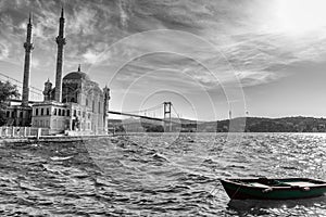 Ortakoy Mosque, the Bosphorus bridge and a boat by the pier, black and white image, Istanbul