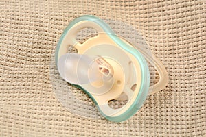 Orthodontic pacifier on a beige background