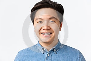 Orthodontics, dental care and stomatology concept. Close-up portrait of handsome asian man with teeth braces, smiling