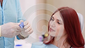 The orthodontist crumples the silicone material for the impression tray that will be placed in the patient`s mouth to shape her