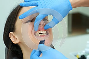 Orthodontist doctor checks the closing of the woman teeth using carbon paper.