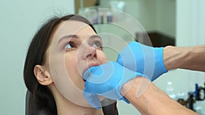 Orthodontist doctor checks the closing of the woman teeth using carbon paper.