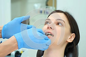Orthodontist doctor checks the closing of the woman teeth using carbon paper.