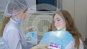 Orthodontist doctor explain girl how to care about silicone braces in dentistry.