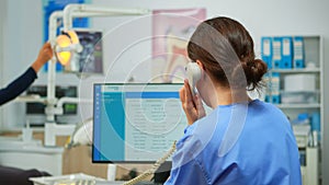 Orthodontist nurse talking at phone making dental appointments