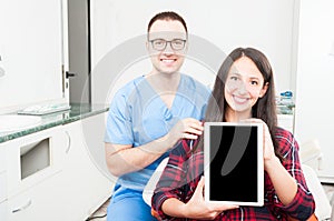 Orthodontist and patient holding tablet and smiling