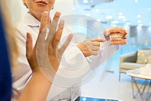 Orthodontist showing jaw to patient