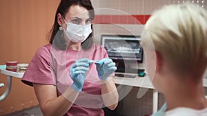 Orthodontist with teen boy and aligners doctor hold device