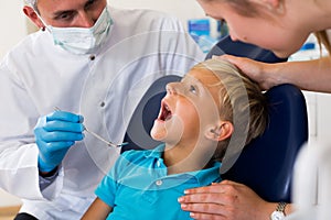 Orthodontist in uniform is taking visional inspection of a teenager