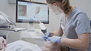 Orthodontist using 3D intraoral scanner for scanning teeth patient's. Modern dental clinic with equipment. Dentistry and