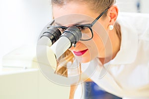 Orthodontist working with microscope and grinder