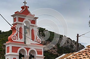 Orthodox bell tower of red color in the Paleokastritsa bay