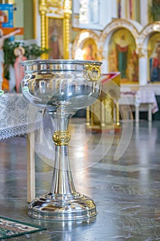 Orthodox bowl of holy water and candles for christening