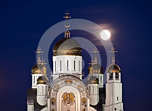 Orthodox cathedral with golden domes and full moon