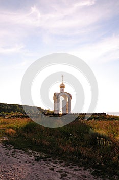 The Orthodox chapel obscures the setting sun by casting a shadow on the clearing