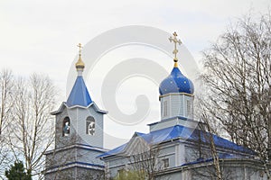 Orthodox Christian church with white walls, blue domes and golden crosses in Russia. A building for religious ceremonies