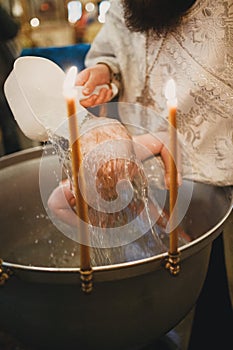 Orthodox Christian priest and little child in the church. Epiphany ceremony rite and font.