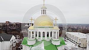 Orthodox church with golden domes in a cloudy winter day. Ukraine, Poltava aerial