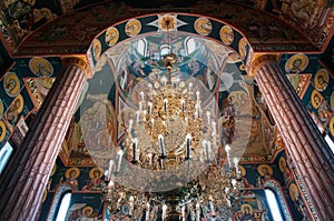 Orthodox church interior with massive chandelier and colorful paintings