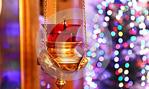 Orthodox church lamp with a lighted candle and red glass