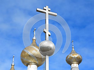 Orthodox crucifixes on golden cupolas in blue sky photo