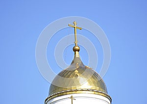 The Orthodox cross, on the dome of the city cathedral, shines in the rays