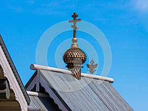 Orthodox cross on the roof of a religious building and a double-headed eagle - Russian coat of arms in the background