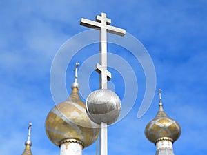 Orthodox crucifixes on golden cupolas in blue sky