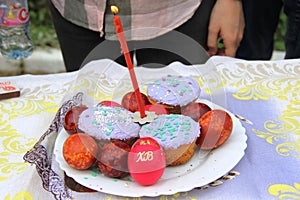 Orthodox Easter, preparation for consecration with Holy water. Easter cakes with a candle and colorful Easter eggs on background