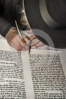 An orthodox hand writing a torah script